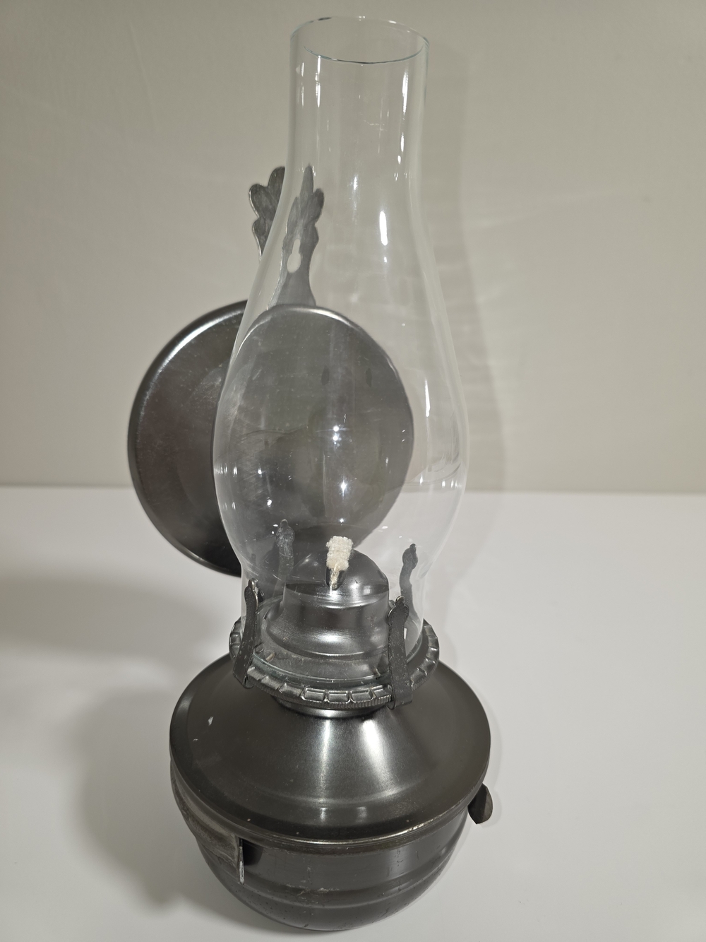 vintage wall-mounted metal kerosene lamp with a clear glass chimney